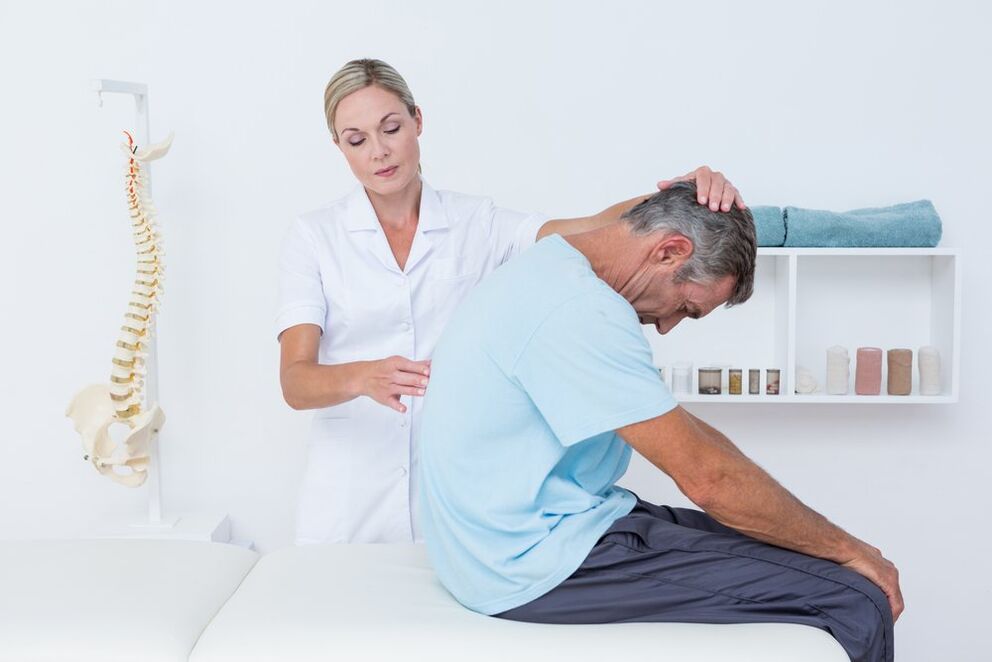 Il medico esamina la schiena con l'osteocondrosi